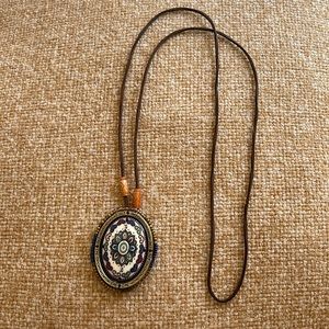 FLASH SALE! $5 Ceramic pendant surrounded by beads on a leather strap.